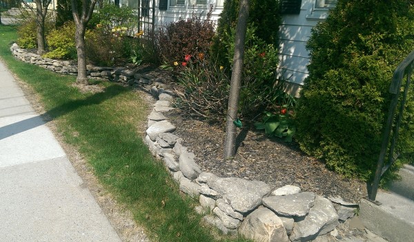 This homeowner used a fieldstone wall to add curb appeal with a low maintenance garden bed. A nice flowing curve along the length of the wall adds a more interesting look.