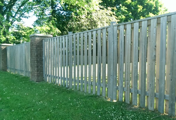 Another option for brick pillars is a wooden fence. They provide a more formal look and solid looking construction.