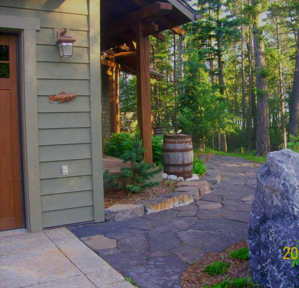 This front entryway is just gorgeous with a flagstone walkway wrapping around the corner past the rain barrel.