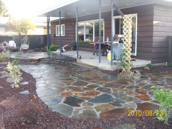 This dry-laid flagstone patio was blended to a lawn using edging and a decorative rock bed.