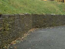 A high retaining wall is used to hold back this steep bank and expand the useable area below it. 