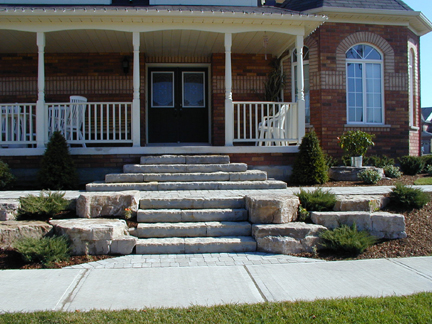Beautiful stone steps split this low maintenance front yard as they lead to the lead to the front door of this home.