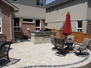 A large nicely shaped patio area with an outdoor kitchen in a typical 