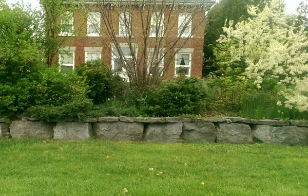 A large block stone wall has a unique look using flagstone as caps.