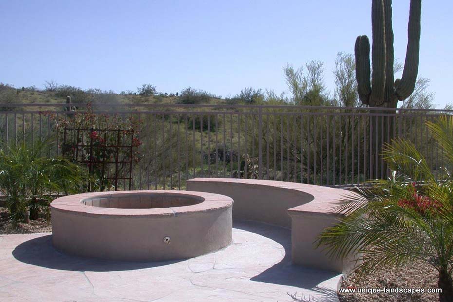 A firepit with seating sits in the corner of this flagstone patio. 