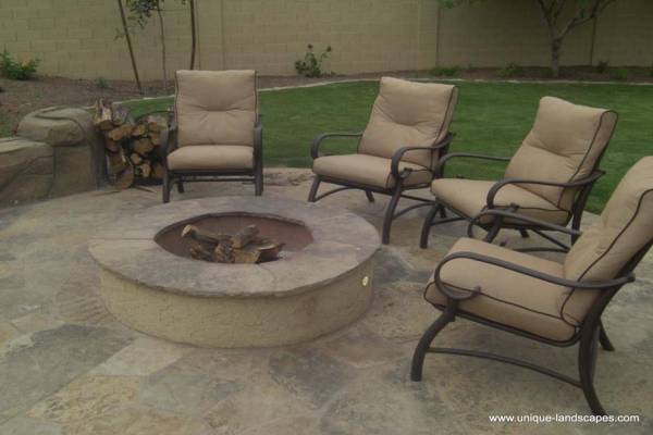 A simple backyard firepit centered in a flagstone patio area.