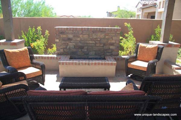 A more formal firepit that adds interest to a large privacy wall with it's shape and materials.