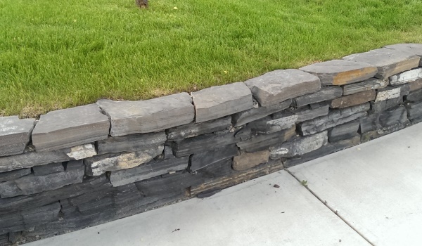 Dry stacked stone wall in Calgary made from Rundlestone. Rundlestone is a popular choice in the region that is quarried from the nearby Banff area.