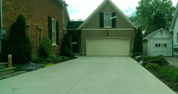 Driveway landscaping done with low groundcovers. These low maintenance gardens eliminate mowing thin strips of grass that scatter the cuttings all over the driveways.