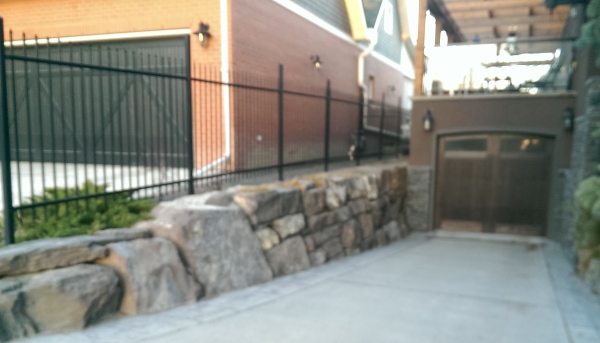 A mixed natural stone retaining wall down the side of a downhill driveway gives lots of character.