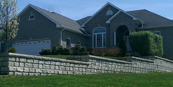 A large block This large manufactured block retaining wall was engineered to level the front yard avoiding a steep slope to mow between properties.