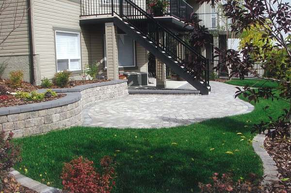 This small sloped city property has been tamed with a retaining wall, patio, and bridge edging. 