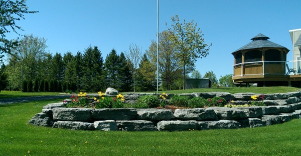 This front yard large stone block wall makes a beautiful planter bed for this cottage. It provides a nice view from the gazebo that overlooks the lake.