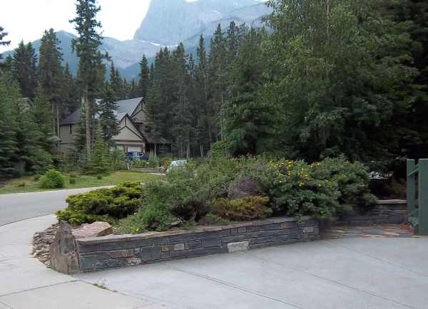 This beautiful low stone retaining wall is a classy way to border a driveway.