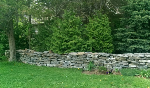A roughly built fieldstone wall adds character to this private country home.