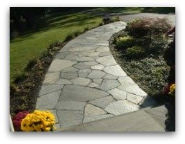 An attractive flagstone walkway with a nice gentle curve from the house to the driveway. Notice the width is wide enough for two people to