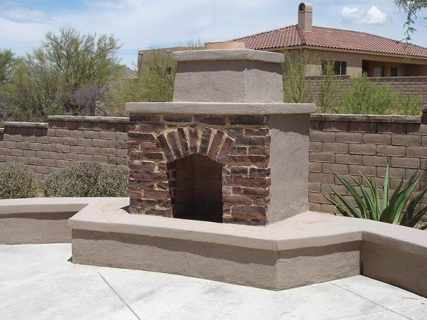 Outdoor desert backyard fireplace combining brickwork into the front face for interest.