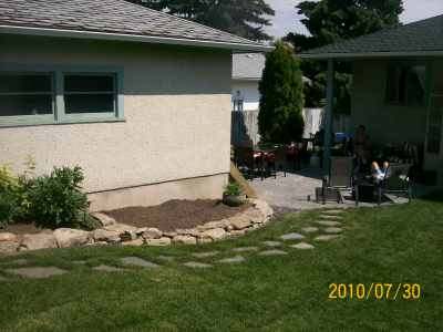 An informal stepping stone walkway leading past a future herb garden to a back gate. 