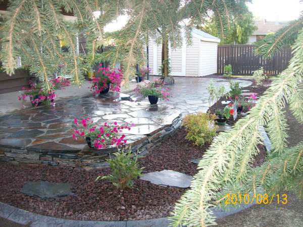 A low two-tiered flagstone patio wraps around the back of this house to the side yard.