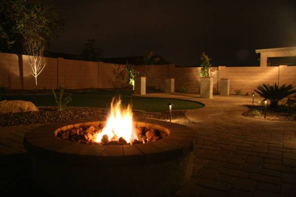 A formal yard is well lit to accent the walkways and trees. 