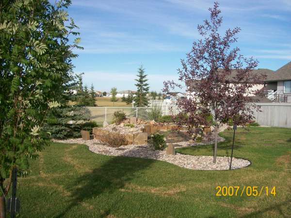 This waterfall feature in the backyard uses decorative rock and edging to transition it to the rest of the yard.