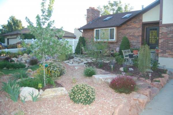 This reduced lawn using alternative ground covers is a great way to lower water consumption. A nice front yard patio makes for a friendly and welcoming home.