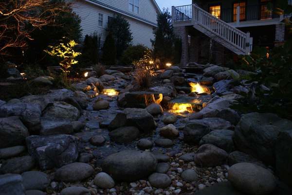 This pondless water feature looks like it came right out of nature with a split stream and a center island planting. 