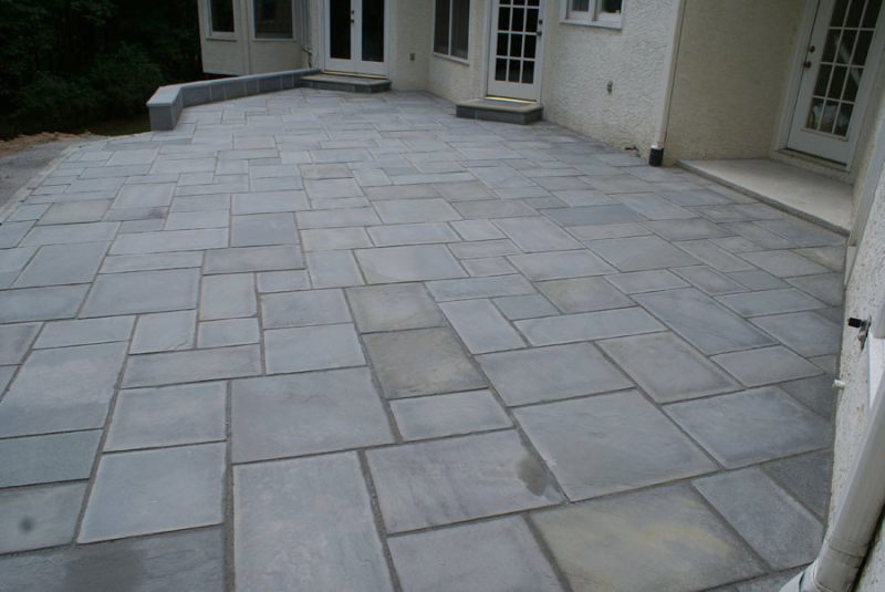 A large formal patio with cut stone in a random pattern.