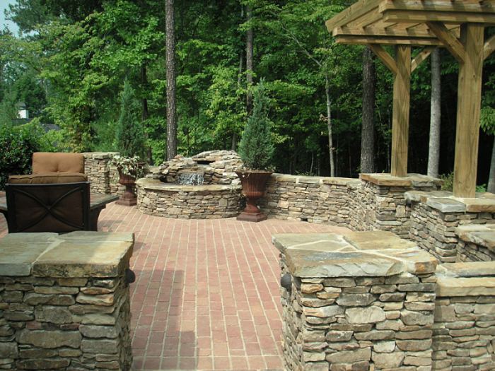 A manufactured brick patio surrounded with natural stone pillars and walls.