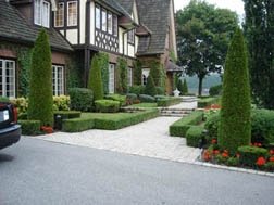 A formal front yard design that is very well manicured.