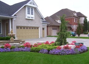 A water fountain in the middle of the brick entryway is a nice touch to this home. The garden bed in front adds colour and contour to the front yard.