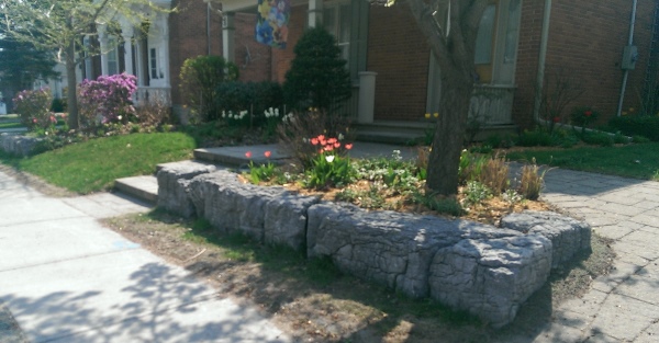 Single large stone blocks are an easy way to make a raised garden bed on a small slope. These stones have tons of character with a weathered facing.