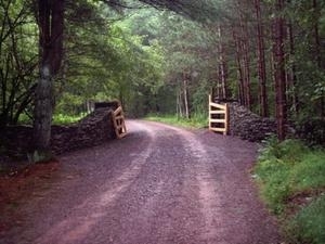 A private road with a rustic stone gate defines the entrance 