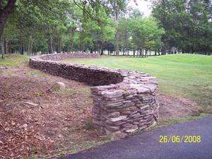 A free standing dry-stacked wall with nice flowing curves meanders across this property.