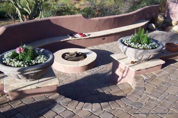 Seating built into the wall makes for a cozy little sunken firepit area off the main patio.