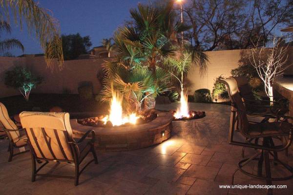 A light show of flames and shadows dance around this patio and onto the walls behind the palm.
