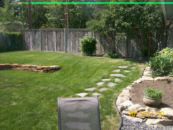 A stepping stone pathway leads from the patio to a back gate. 