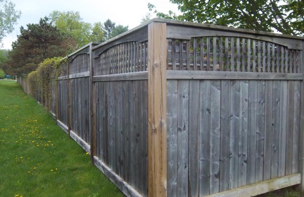 This standard board fence has some added appeal with a molding style wooden cap on top of lattice.