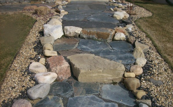 A mixed stone walkway with lots of character welcomes visitors to this home.