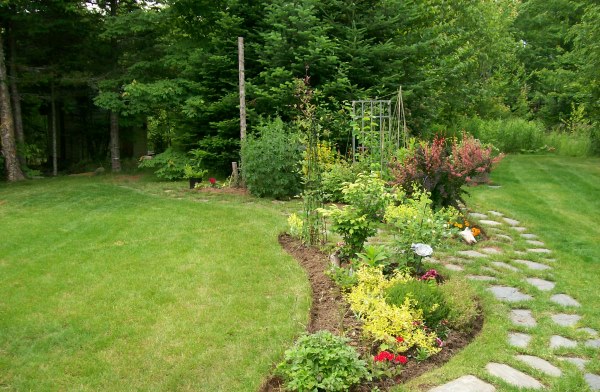 A naturalistic blended theme with garden beds in front of native trees and shrubs left at the time of clearing the lot. This property is less than 3 years old.