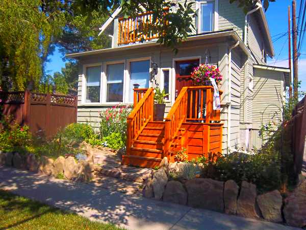 Creative edging idea using standing flagstone (soldiering), to give this small front yard garden some character.